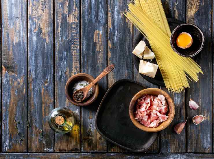 Ingrendienti per fare una carbonara appoggiati su di un tavolo